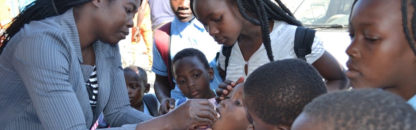 A young girls receives an oral dose vaccine