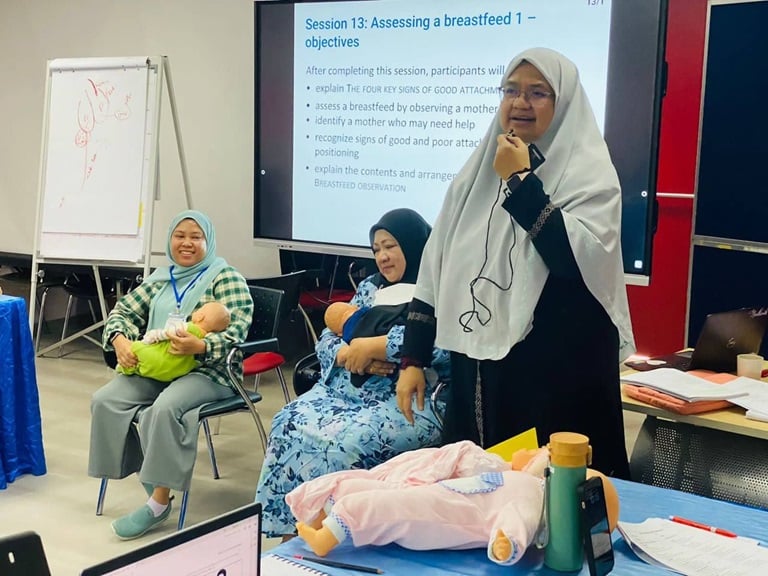 A female trainer from the World Alliance for Breastfeeding Action speaks with participants